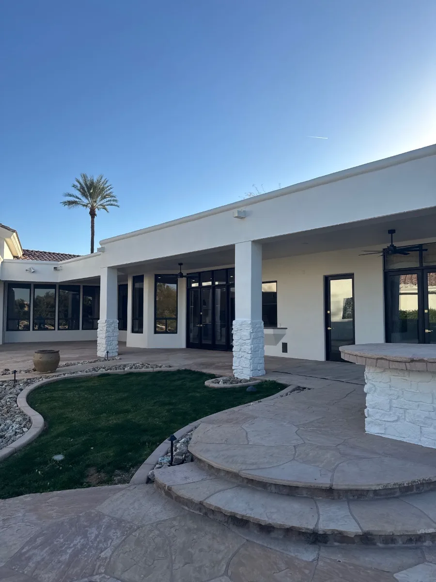 Finished Paradise Valley courtyard with light walls, painted stone columns and black windows