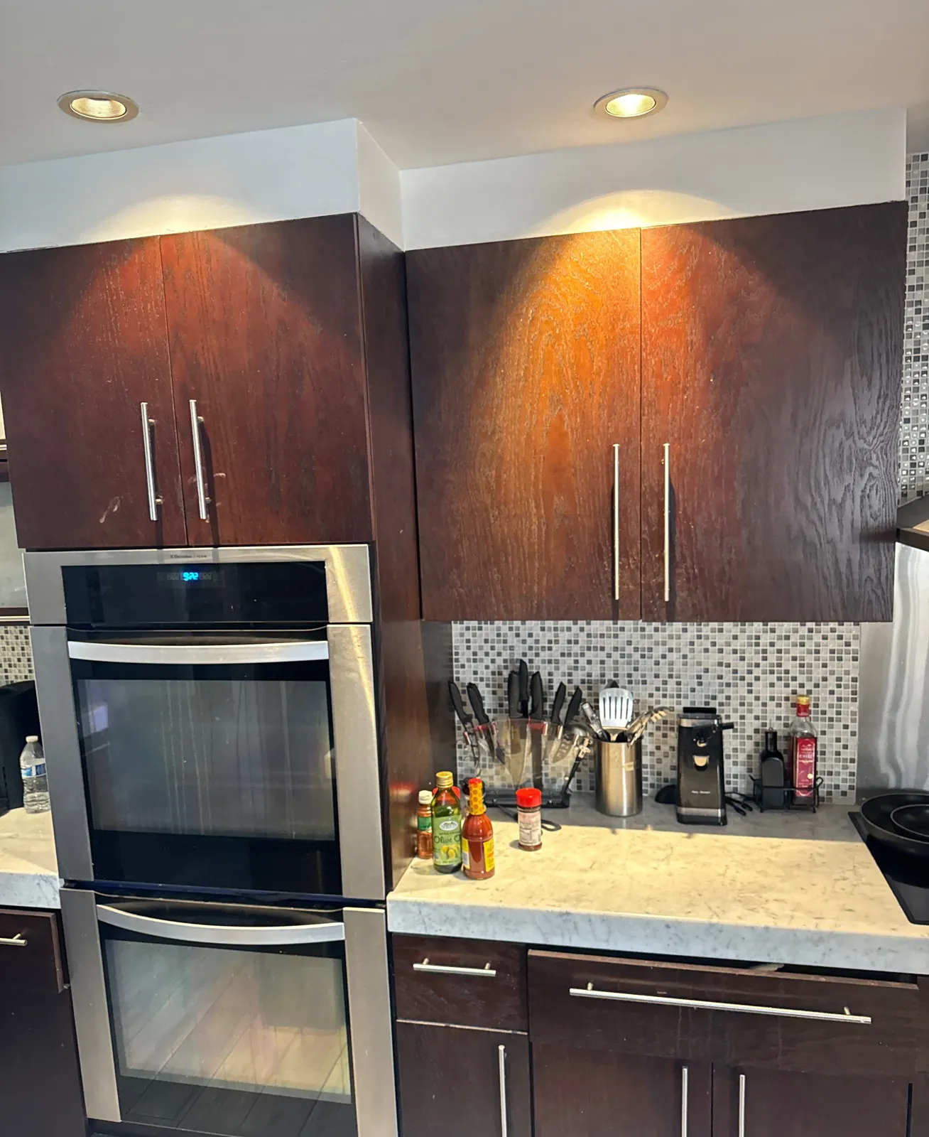 Tall espresso cabinets with visible wood grain above a double wall oven